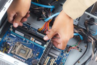 photo of hands placing card into computer